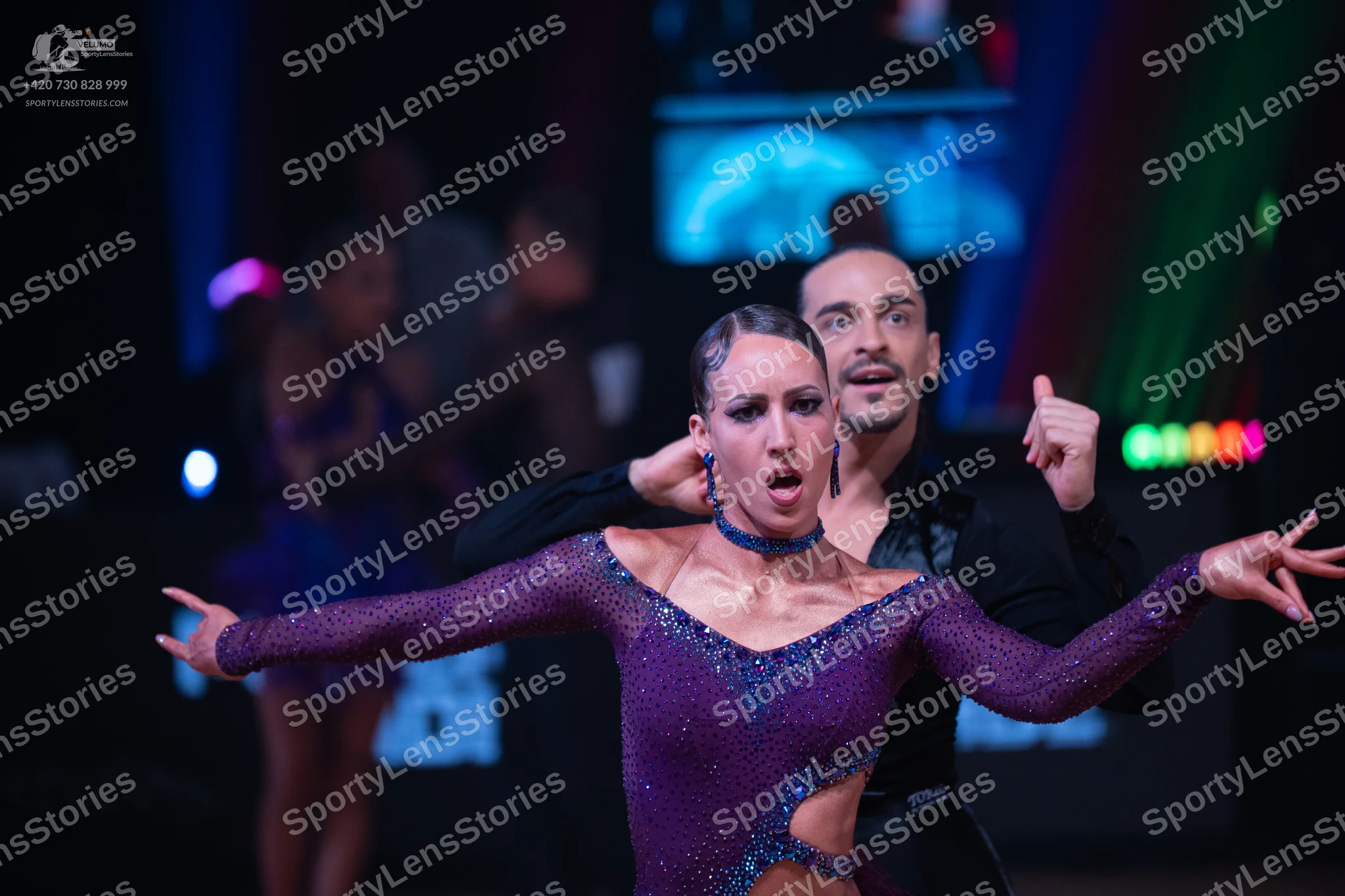 Dancesport competitor: Female dancer: purple long-sleeved latin dress embellished with small sequins, f