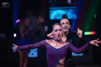 Dancesport competitor: Female dancer: purple long-sleeved latin dress embellished with small sequins, f
