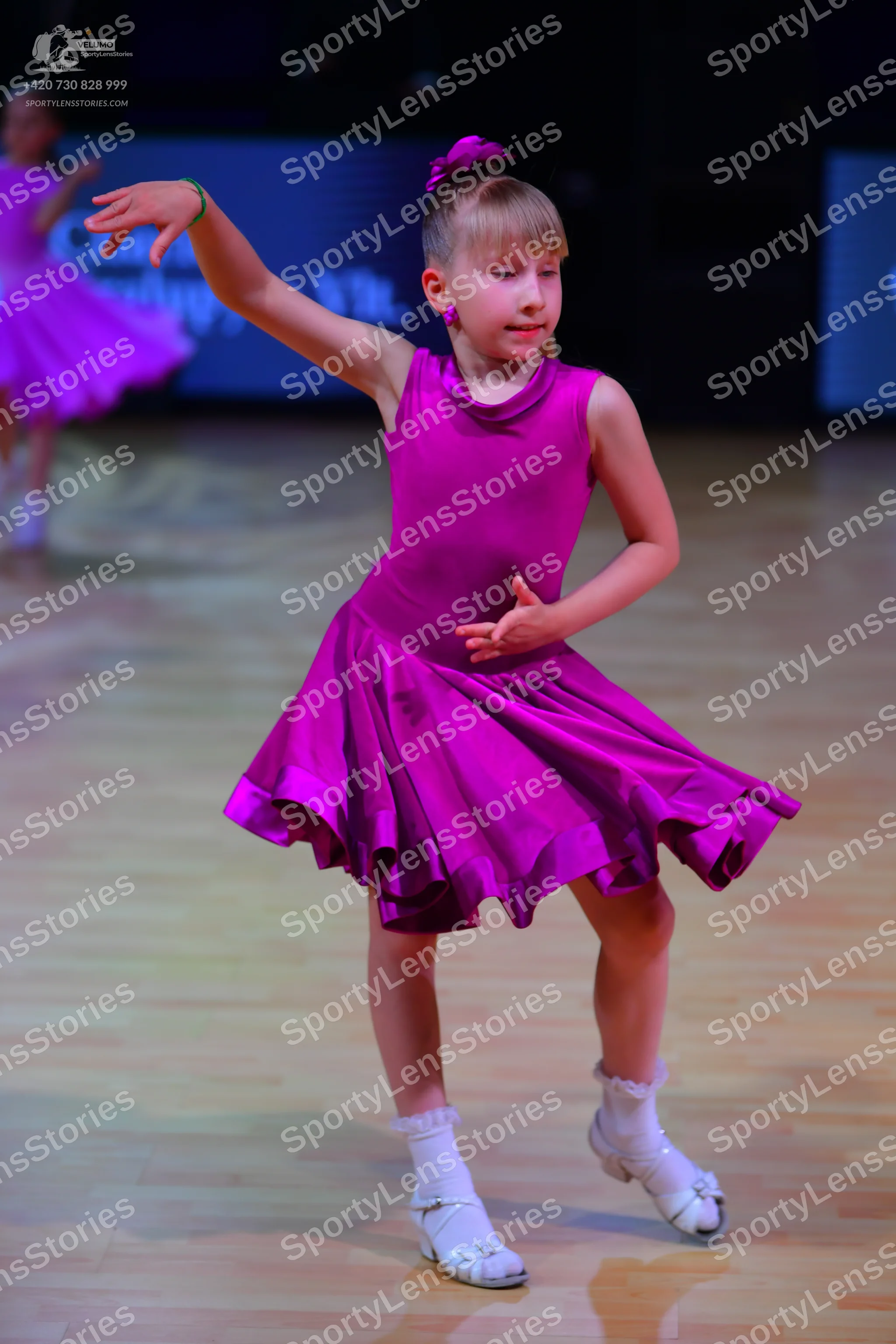 Dancesport competitor: Female dancer: magenta sleeveless dress with a flared skirt, smooth fabric