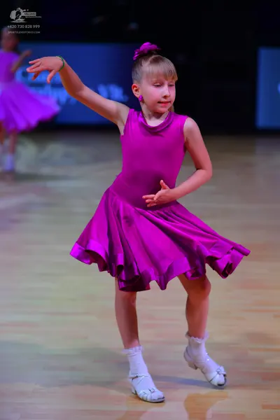 Dancesport competitor: Female dancer: magenta sleeveless dress with a flared skirt, smooth fabric