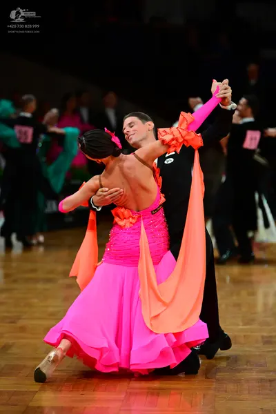 Dancesport competitor #39, #81: Female dancer: bright pink Latin dress with a sequined bodice, a flowing pink sk