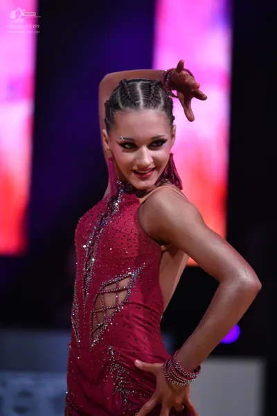 Dancesport competitor: Female dancer: burgundy Latin dance dress with rhinestone/sequin embellishments 