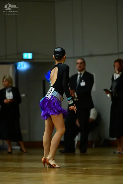 Dancesport competitor #10: Female dancer: black long-sleeved top with an open back and a silver sequin wais