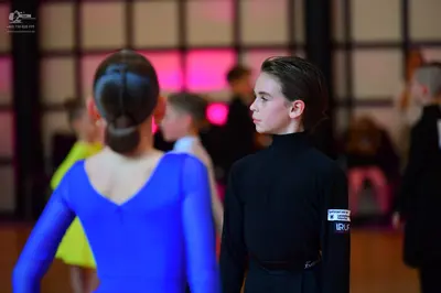 Dancesport competitor: Female dancer: blue, long-sleeved, tight-fitting dress made of smooth fabric