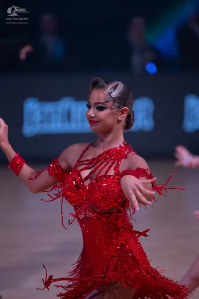 Dancesport competitor: Female dancer: red Latin dress with sequins and fringe, and a matching red sequi