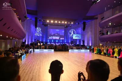 Dancesport competitor: The dancers on the right side of the floor are wearing a variety of colorful Lat