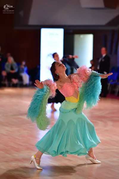 Dancesport competitor: Female dancer: light blue ballroom dress with a voluminous skirt, featuring larg