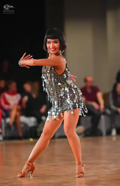 Dancesport competitor #115: Female dancer: black latin dress with silver sequins and large silver disc fring