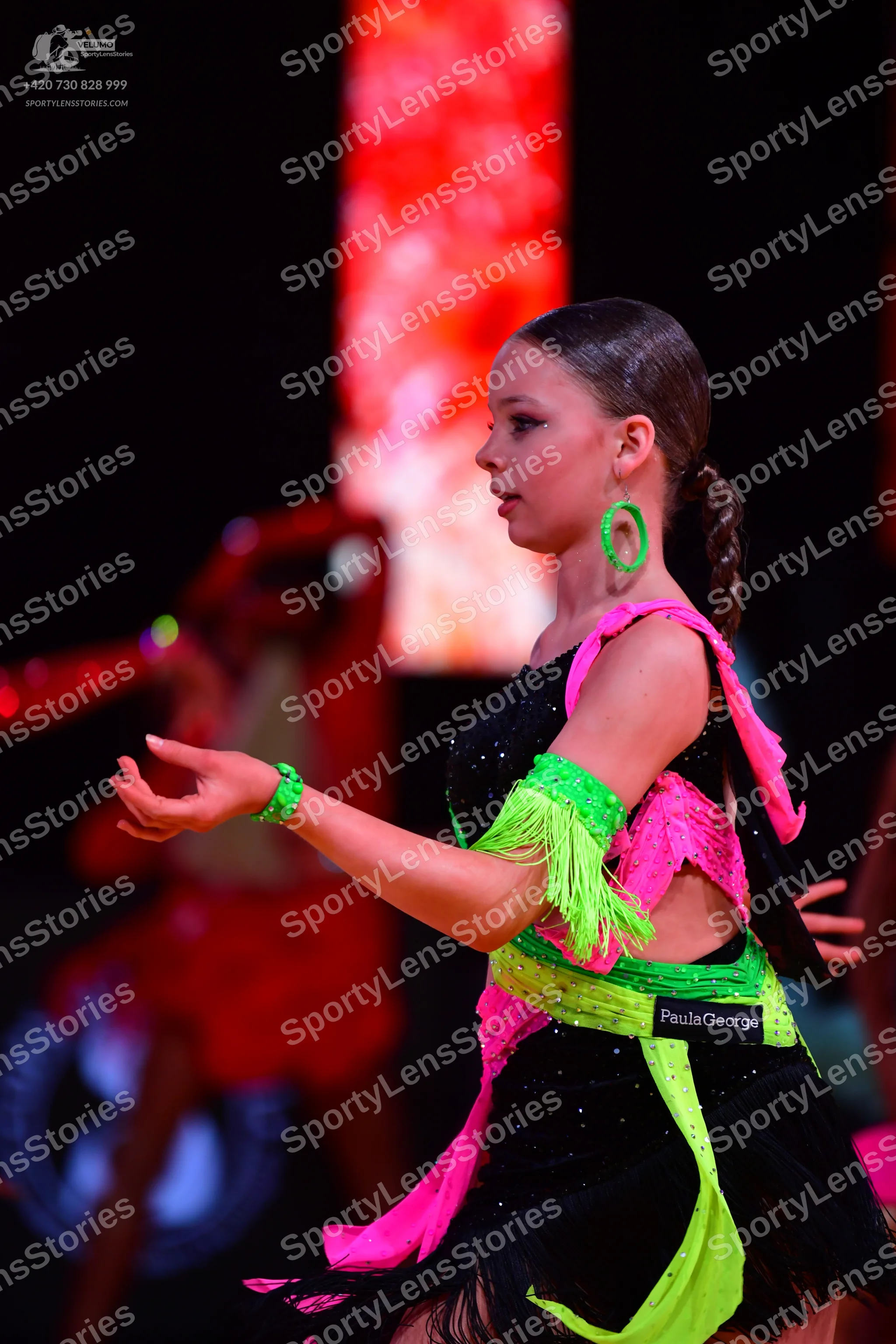Dancesport competitor: Female dancer: black Latin dress with neon green and bright pink fringe and fabr