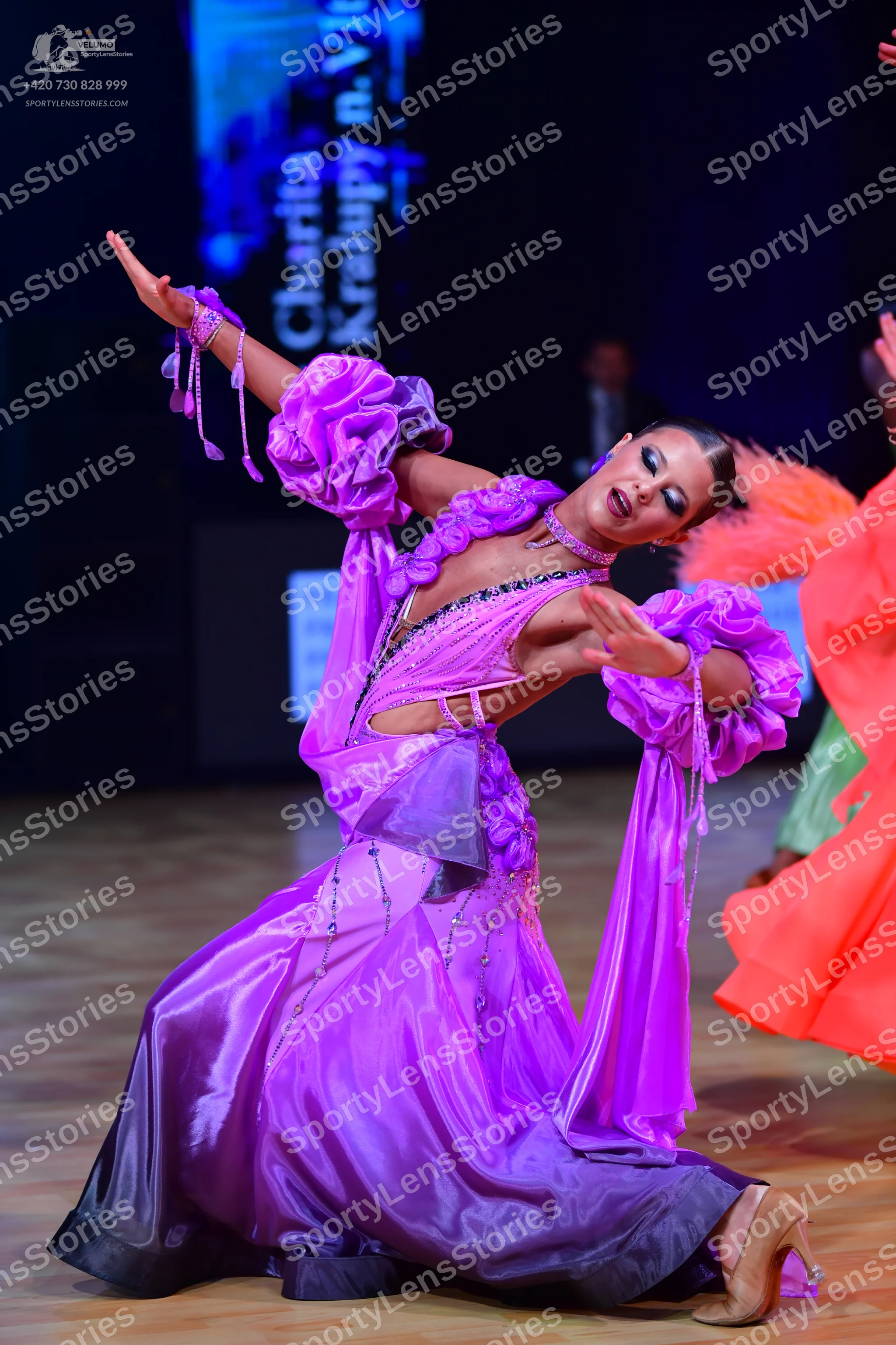 Dancesport competitor: Female dancer: purple and dark purple satin ballgown with large ruffled sleeves