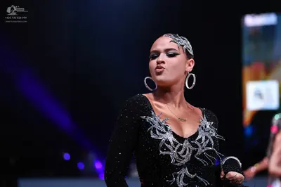 Dancesport competitor: Female dancer: black long-sleeved latin dress with silver/white sequin or crysta