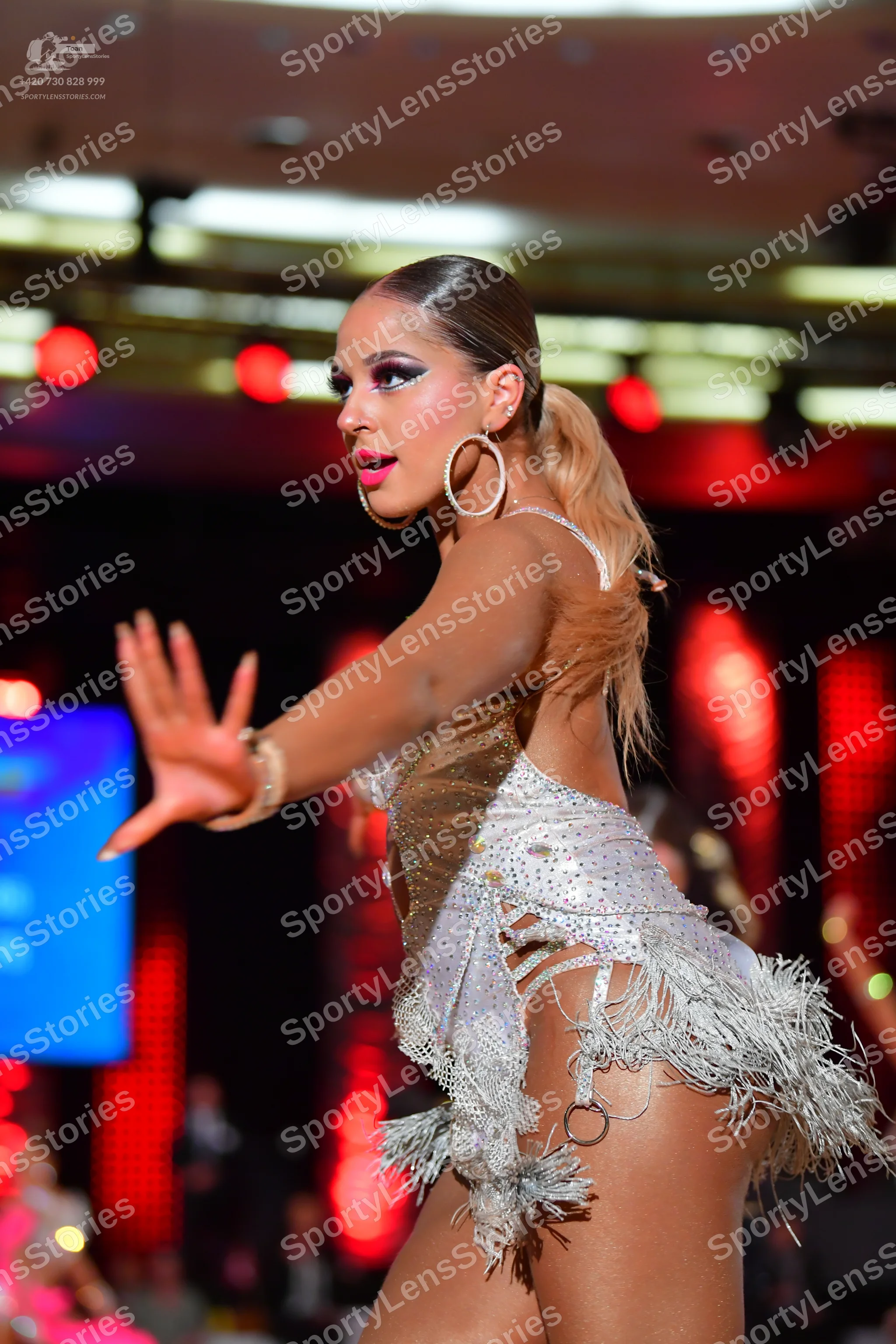 Dancesport competitor: Female dancer: silver/white latin dance dress with sequins and fringe, wearing l