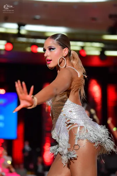 Dancesport competitor: Female dancer: silver/white latin dance dress with sequins and fringe, wearing l