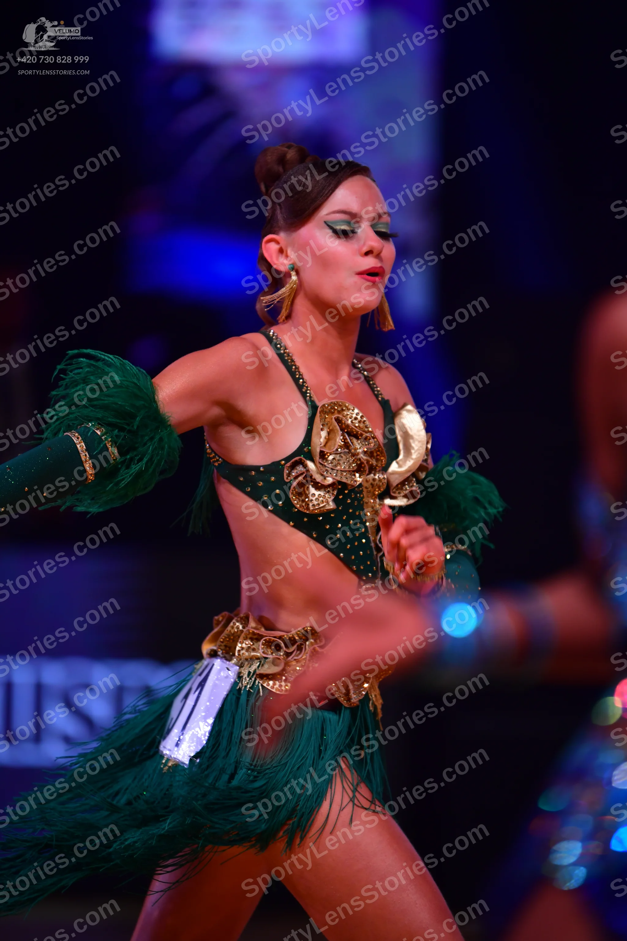 Dancesport competitor: Female dancer: emerald green Latin dance costume with a sequined crop top and sk