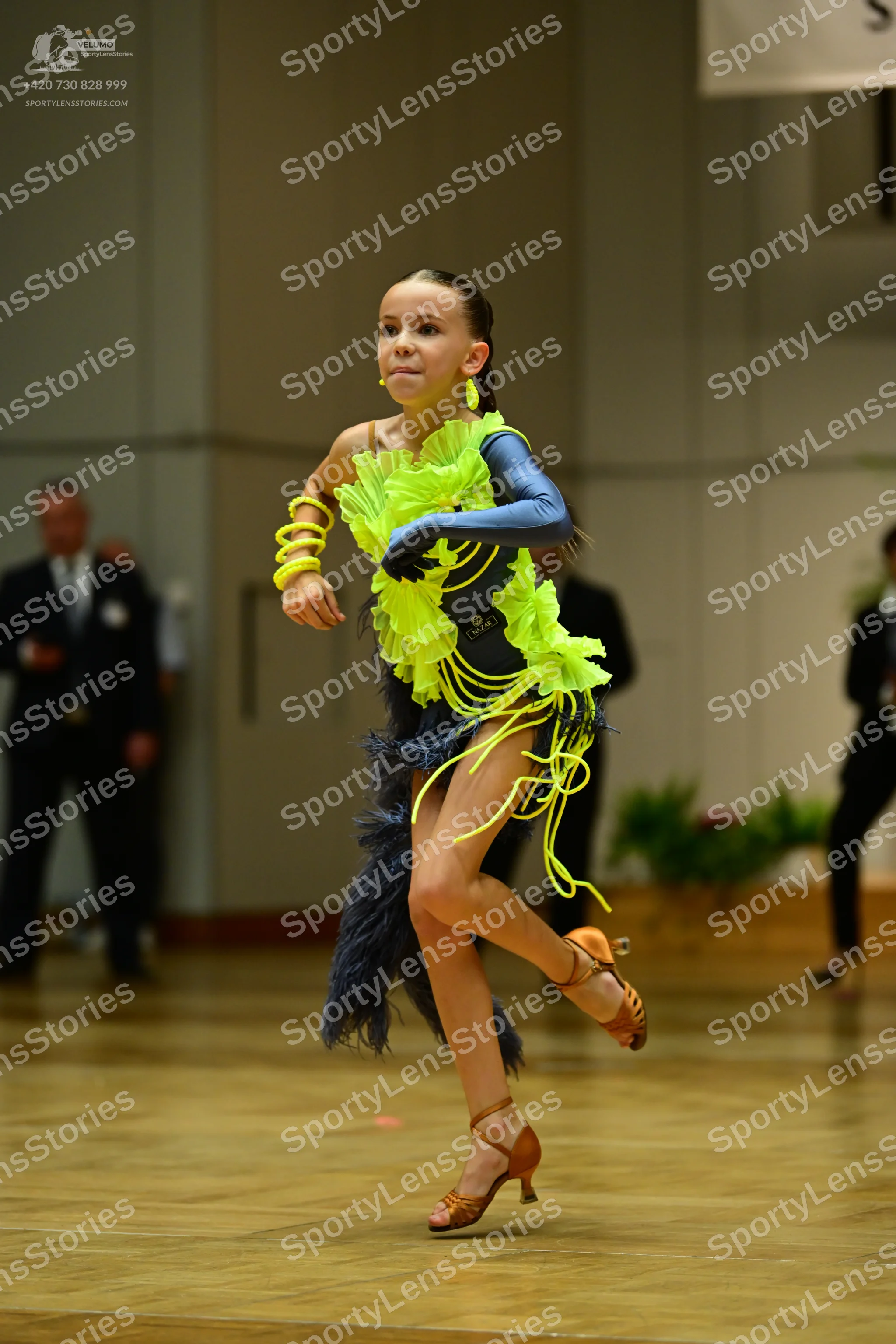 Dancesport competitor: Female dancer: bright lime green/yellow Latin dance dress with a ruffled bodice,