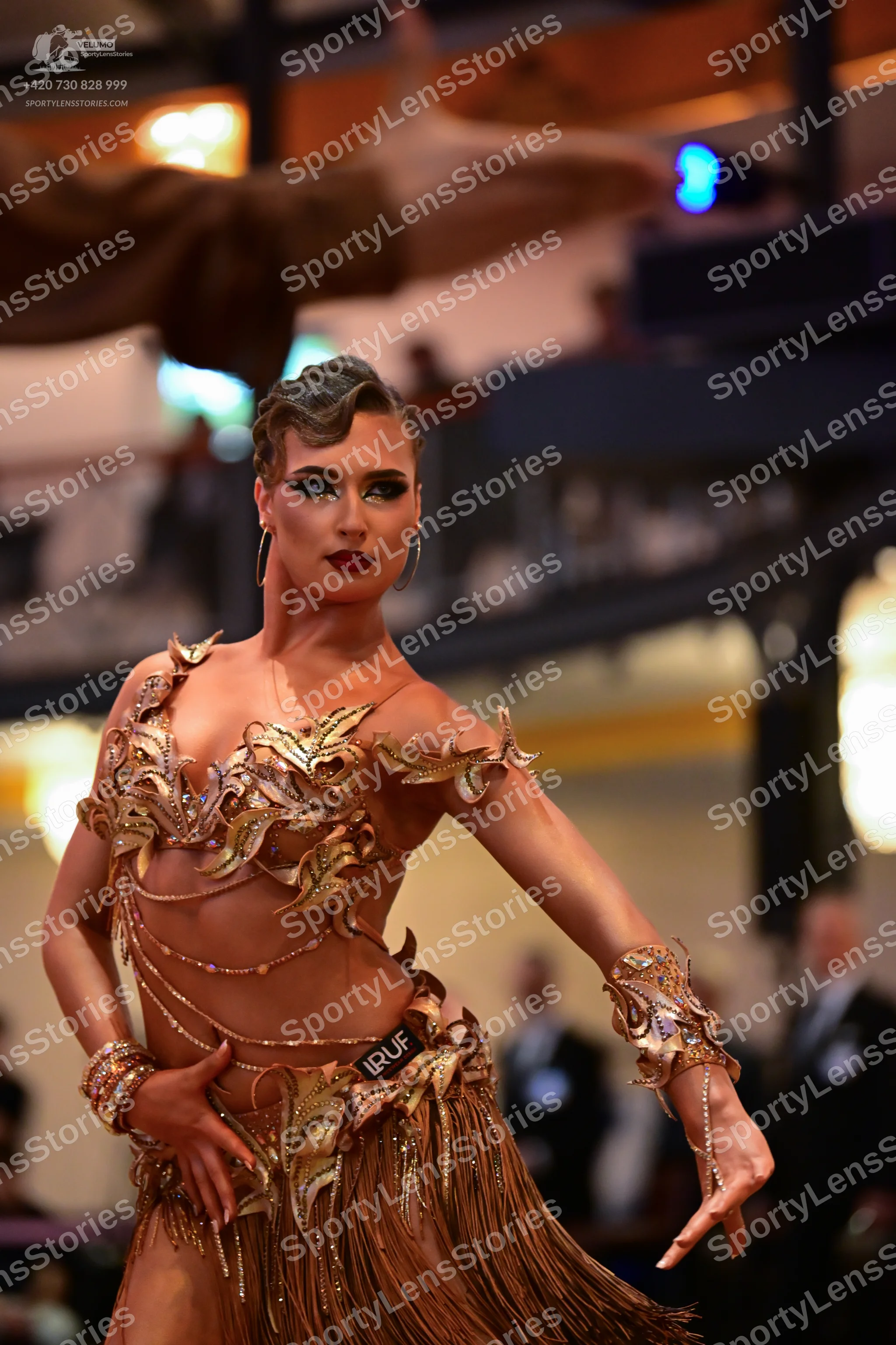 Dancesport competitor: Female dancer: gold/bronze Latin dance dress with intricate sequin and bead embe