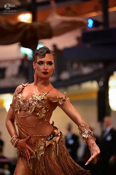 Dancesport competitor: Female dancer: gold/bronze Latin dance dress with intricate sequin and bead embe