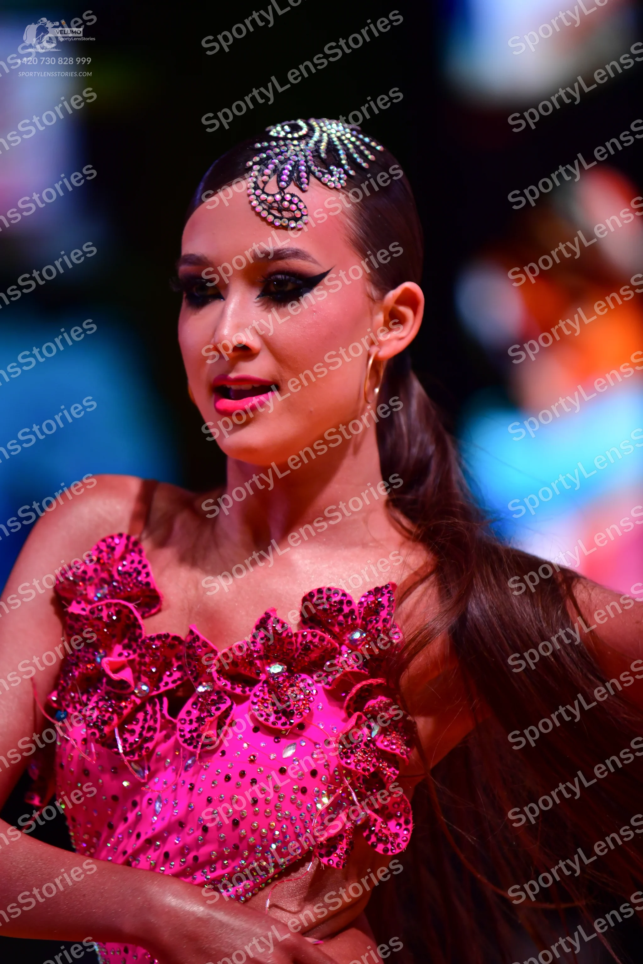 Dancesport competitor: Female dancer: bright pink latin dress with large 3D floral appliqués, heavily e