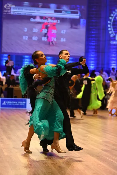Dancesport competitor: Female dancer: teal latin dress with a black sequined/lace bodice and large blac