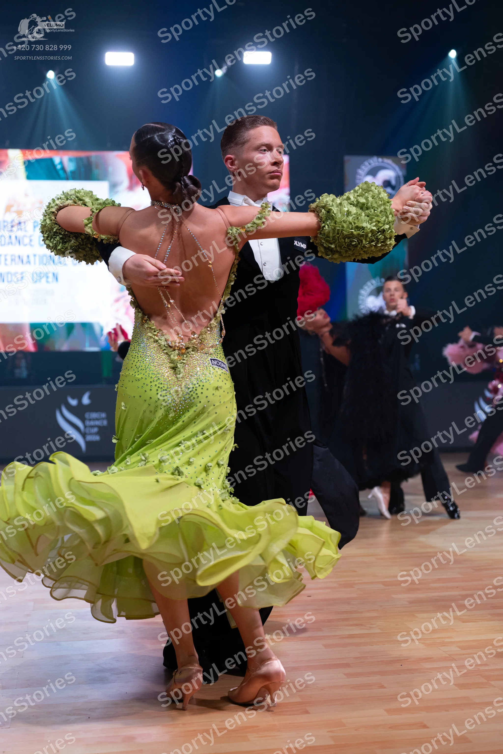 Dancesport competitor: Female dancer: lime green Latin dress with a multi-layered ruffled skirt, puffy
