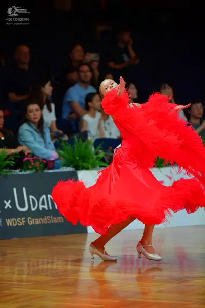 Dancesport competitor: Female dancer: bright red Latin dance dress with voluminous feathers or fringe