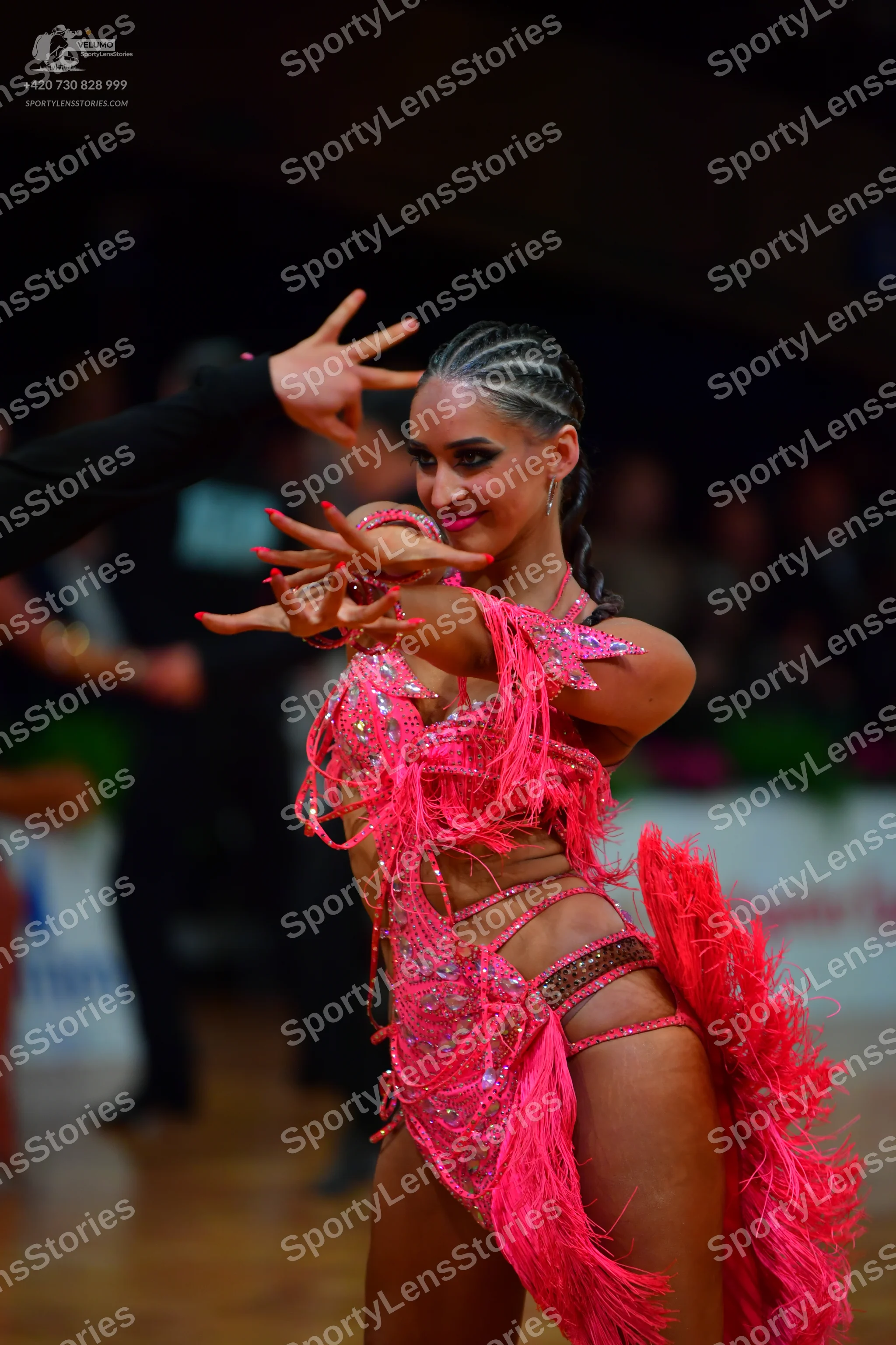 Dancesport competitor: Female dancer: bright pink Latin dance costume featuring extensive fringe, sequi