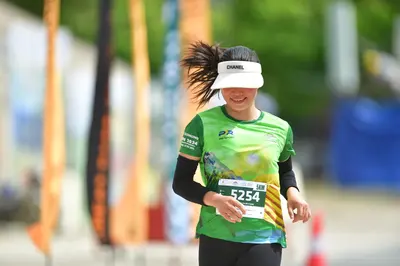 Marathon runner #5254: Runner 1: green jersey, black long sleeves, black leggings, white visor