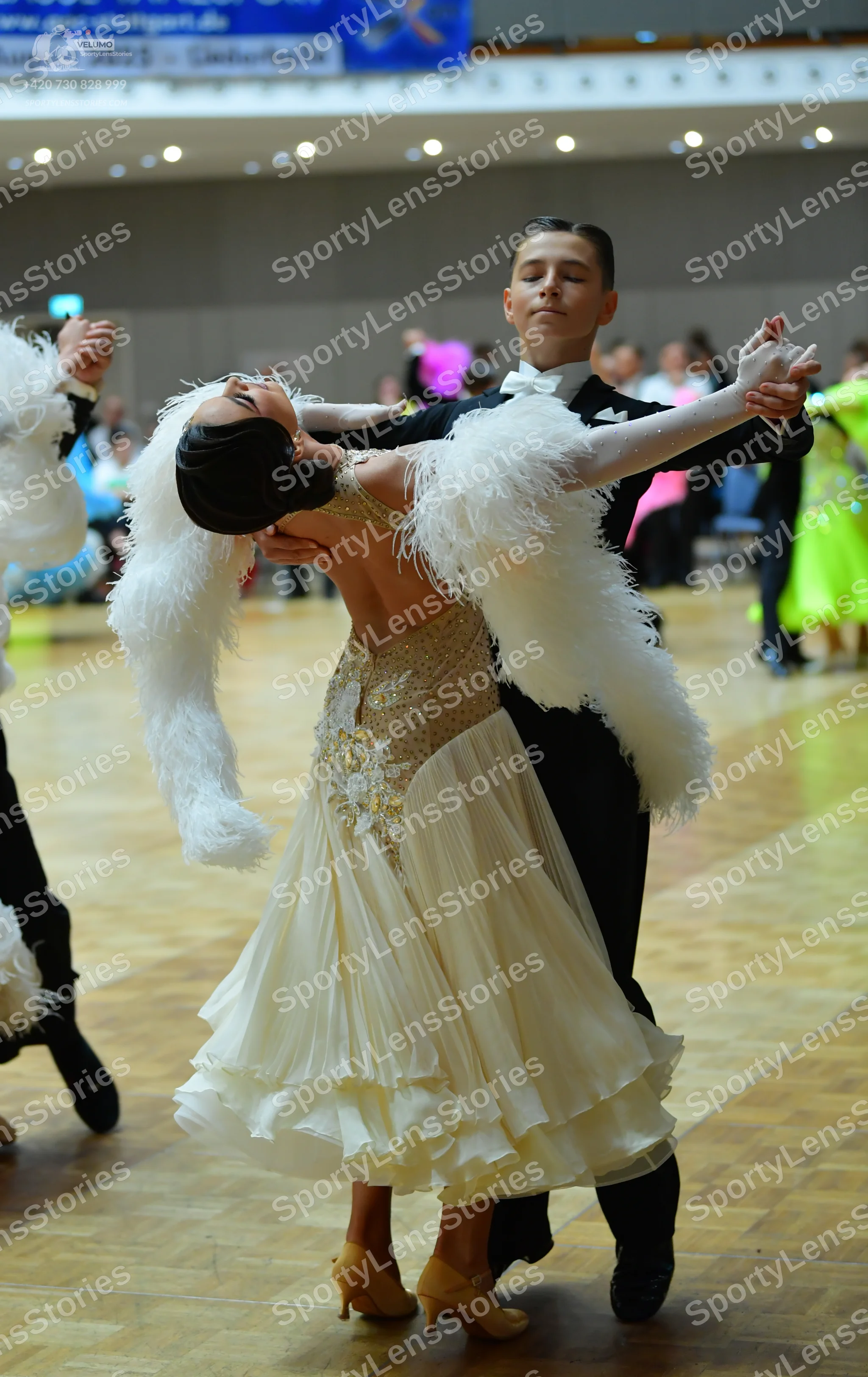 Dancesport competitor: Female dancer: cream-colored ballroom gown with a sequined and beaded bodice and