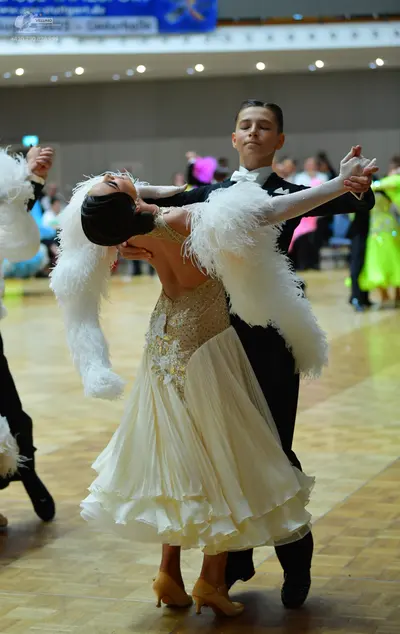 Dancesport competitor: Female dancer: cream-colored ballroom gown with a sequined and beaded bodice and
