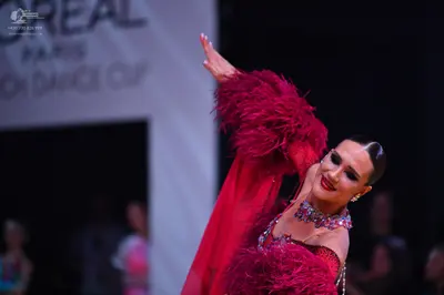 Dancesport competitor: Main dancer: red Latin dress with large feather or faux fur embellishments on th
