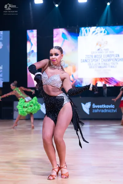 Dancesport competitor: Female dancer (foreground): silver sequin crop top, black sequin and fringe Lati