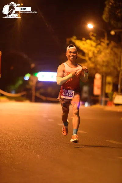 Marathon runner #42459: Runner 1: orange tank top, patterned light-colored shorts, white headband, light
