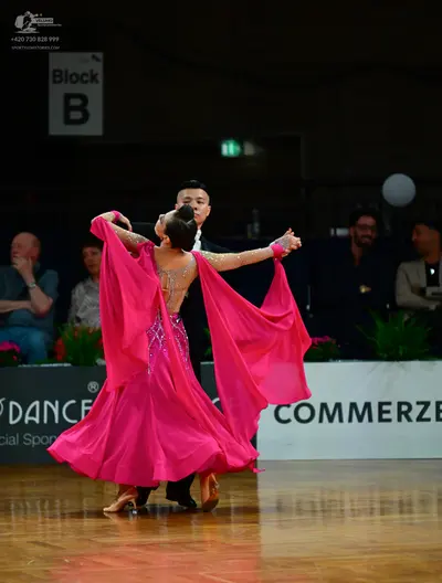 Dancesport competitor: Female dancer: voluminous pink ballroom gown with an embellished, nude-toned bod