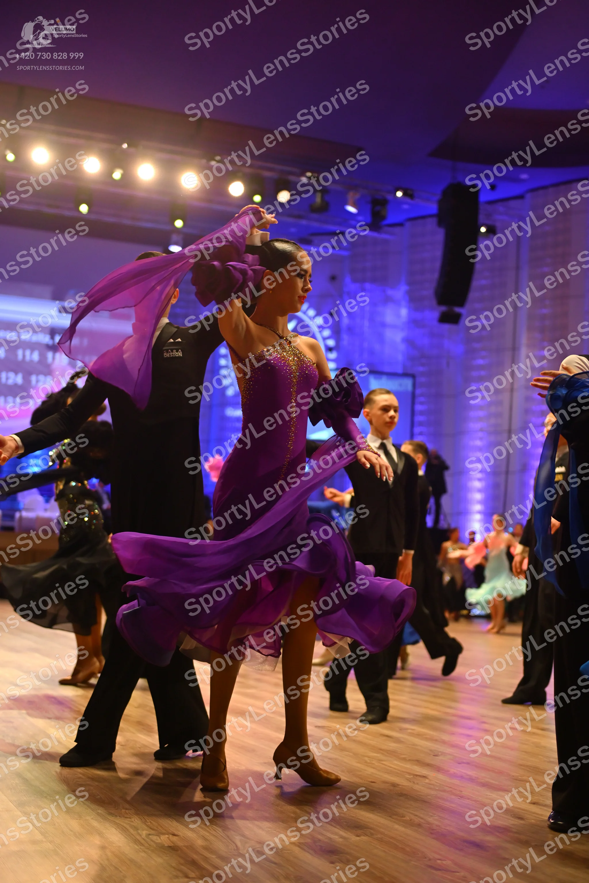 Dancesport competitor: Main female dancer: purple ballroom dress with a flowing chiffon skirt and volum