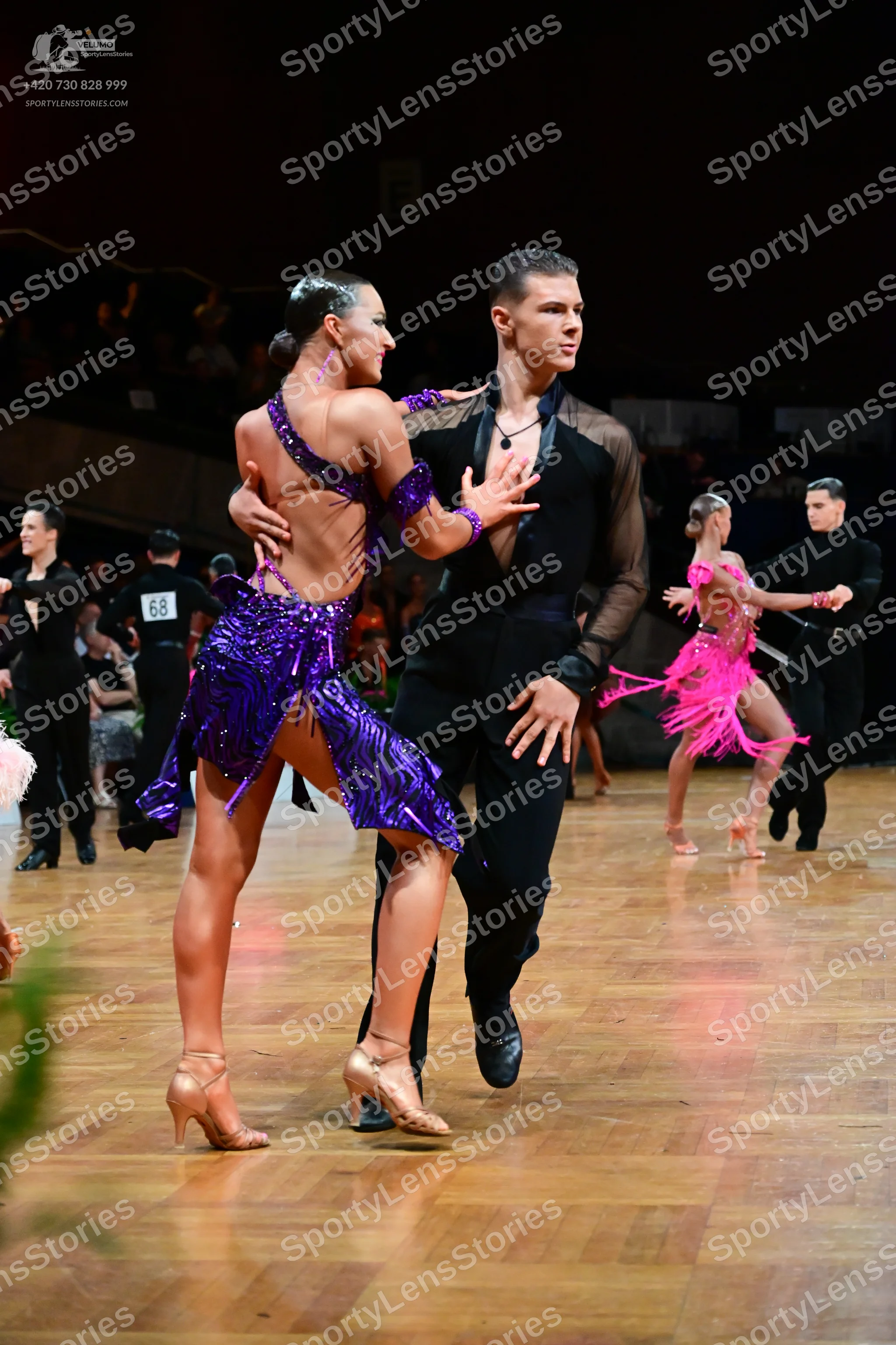 Dancesport competitor #68: Primary female dancer: purple sequined Latin dress with thin straps and an open