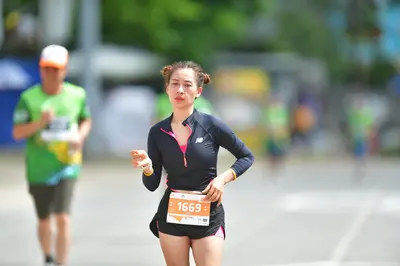 Marathon runner #1669: Runner 1: black long-sleeved top with pink zipper, black shorts with pink trim, 