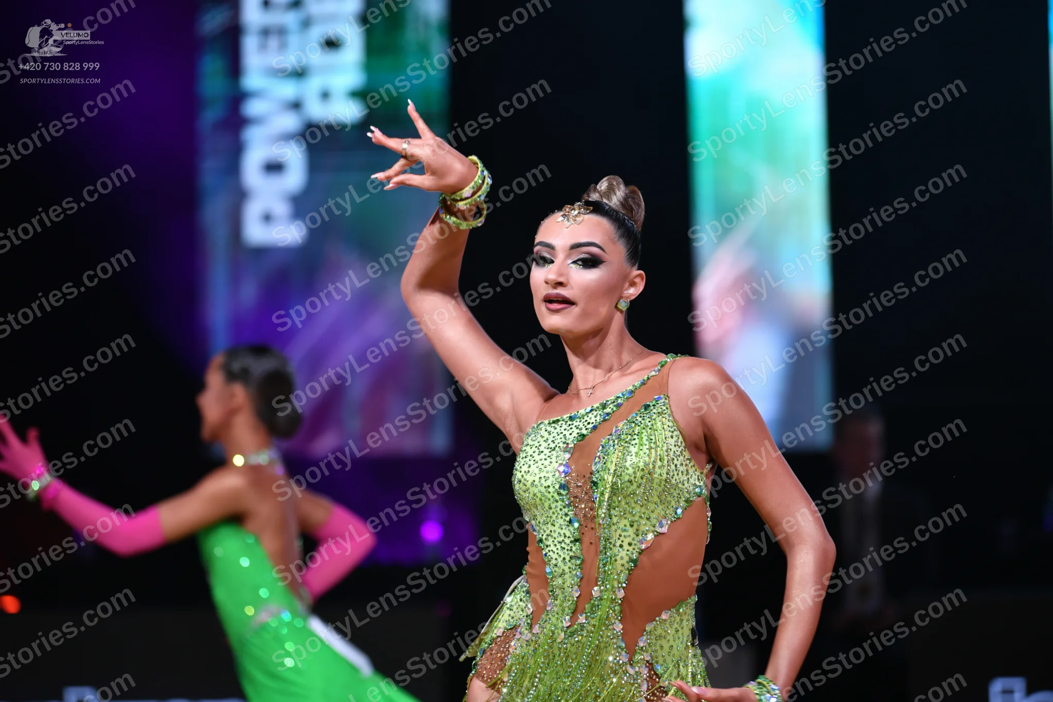 Dancesport competitor: Female dancer in foreground: lime green latin dress with sequins and mesh panels
