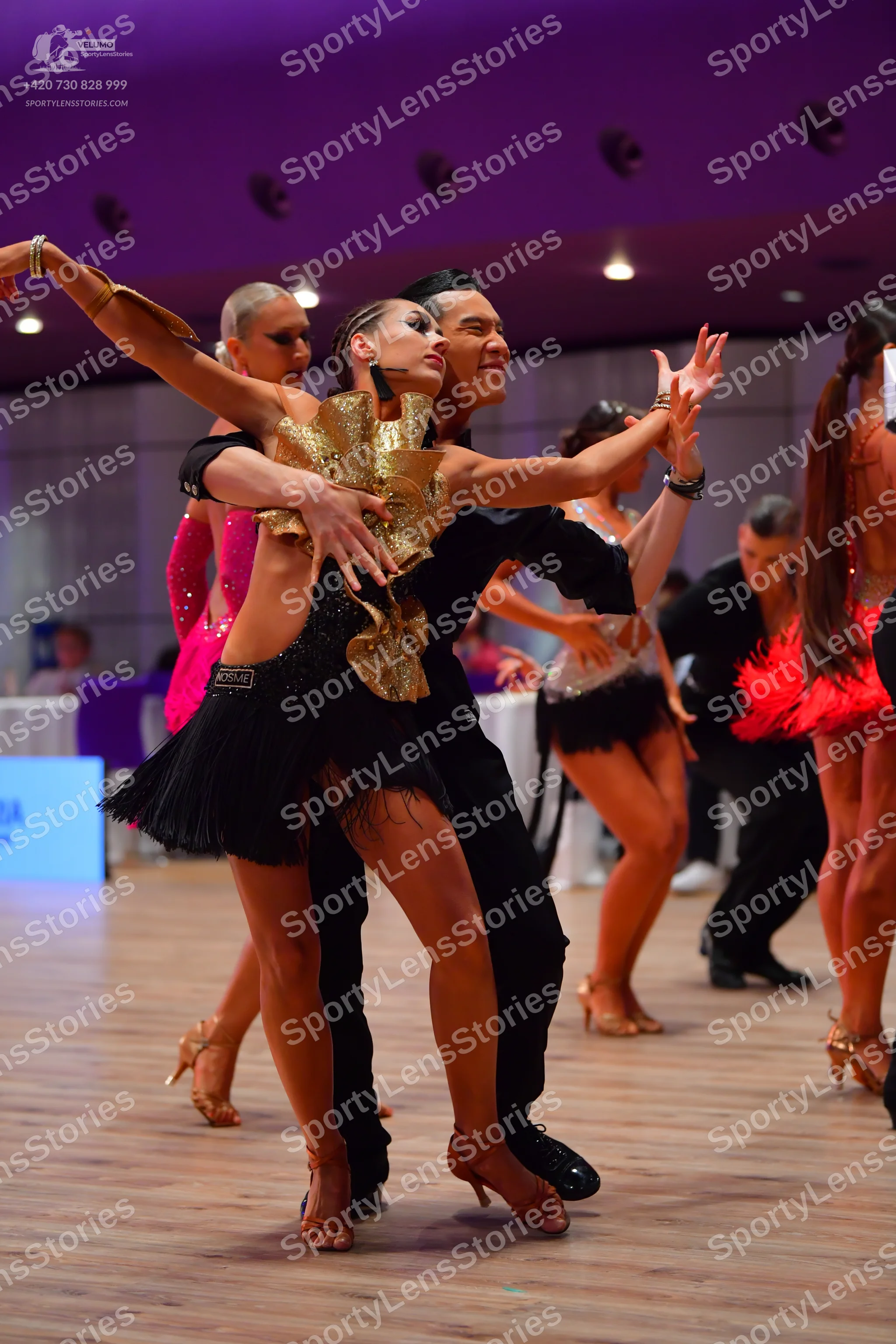 Dancesport competitor: Female dancer (left): pink sequined Latin dress