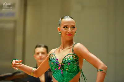 Dancesport competitor: Female dancer: green latin dance bodysuit with sequins and multicolored embellis