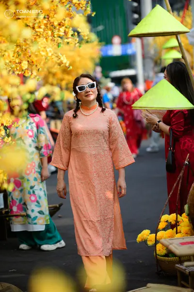 Dancesport competitor: Female dancer 1: peach-colored patterned tunic dress with wide sleeves and match
