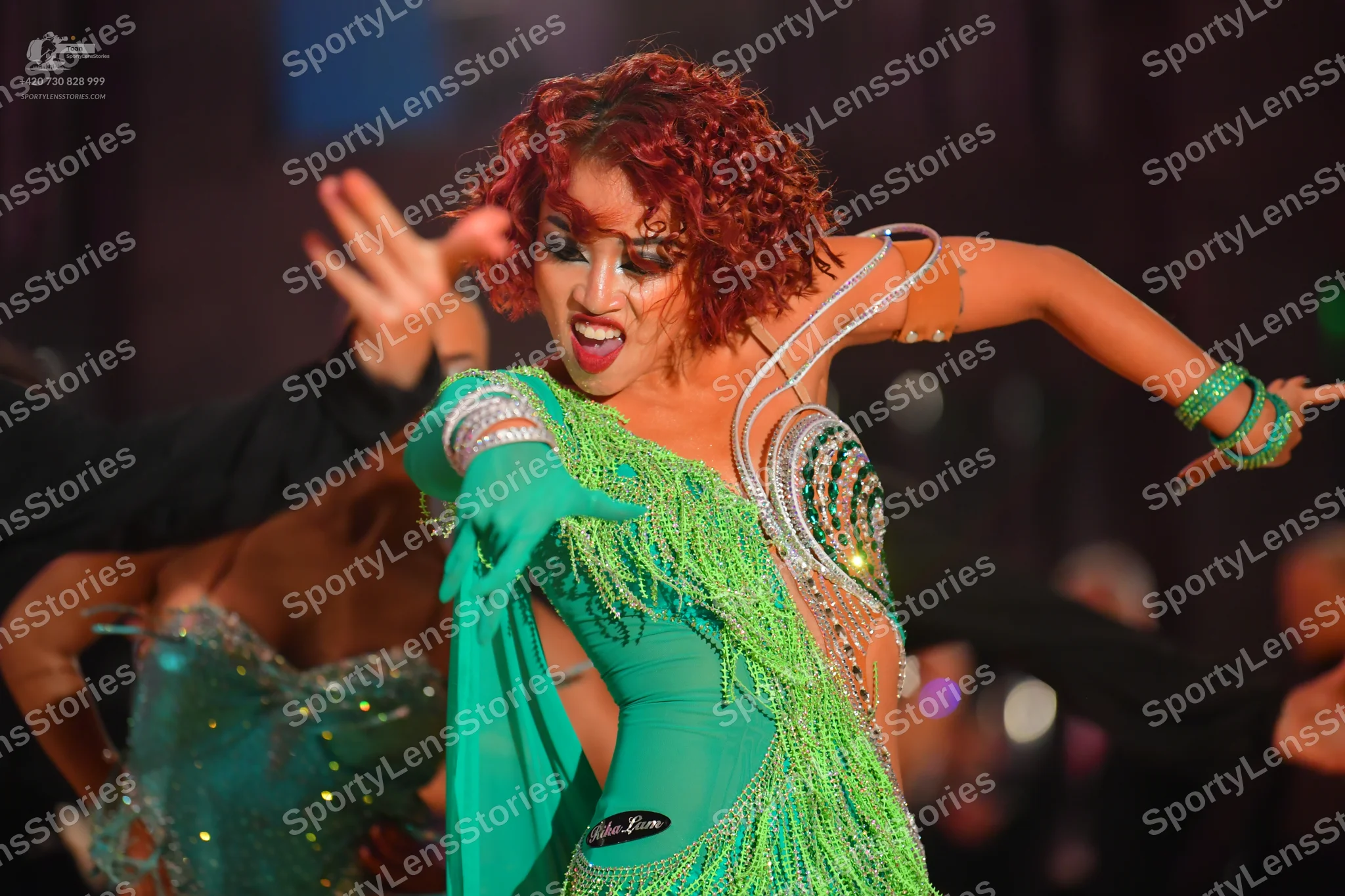 Dancesport competitor: Female dancer: lime green latin dress with long fringe, sequins, and rhinestone
