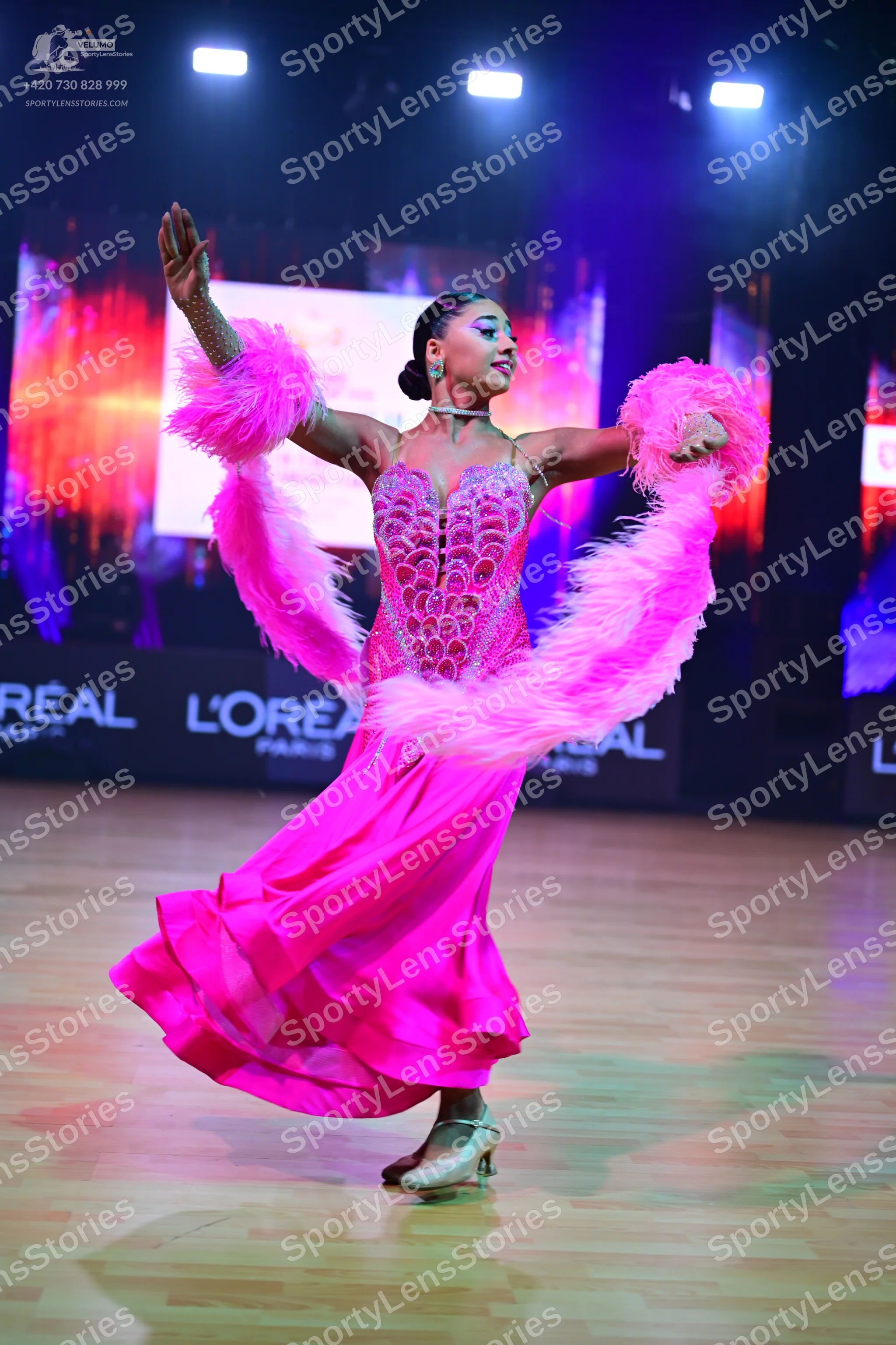 Dancesport competitor: Female dancer: bright pink ballroom dress with a heavily sequined/rhinestone-enc