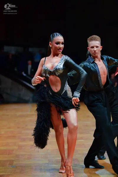 Dancesport competitor: Female dancer: black Latin dance costume with long sleeves, silver sequin embell