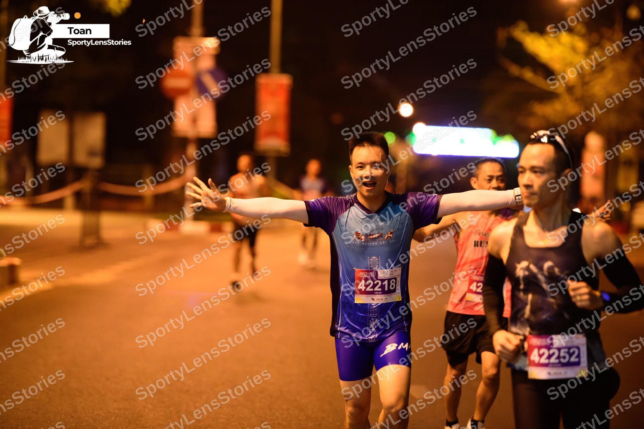 Marathon runner #42218, #42252: Runner 1: blue and purple short-sleeve jersey, white long sleeves, blue shorts