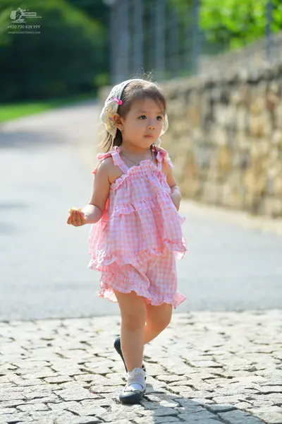 Dancesport competitor: Female dancer: pink and white gingham ruffled dress with a white floral headband