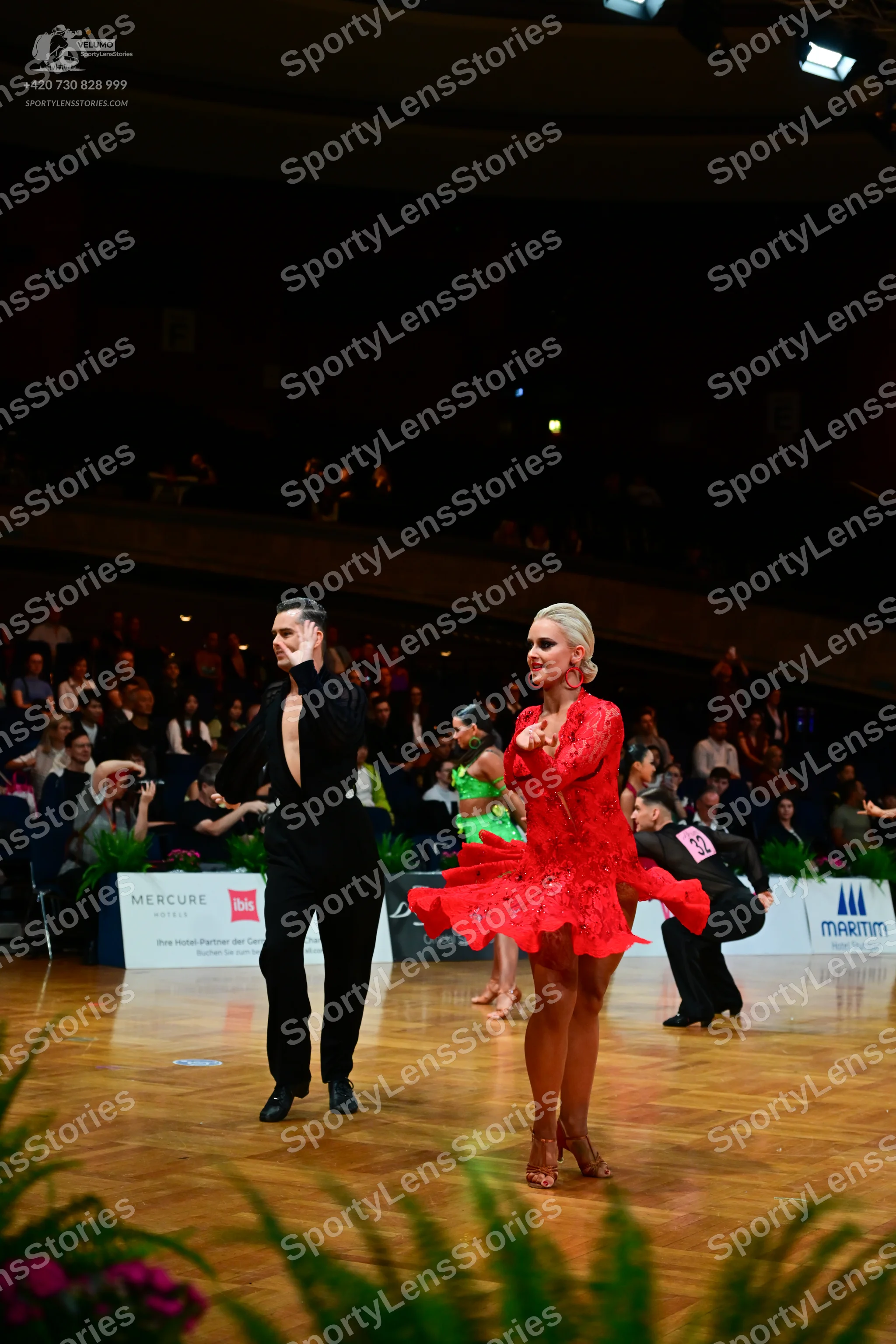Dancesport competitor: Male dancer (foreground): black long-sleeved shirt and black trousers