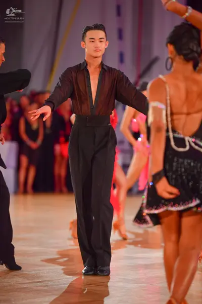 Dancesport competitor: Male dancer: black semi-transparent long-sleeved shirt with a deep V-neckline an