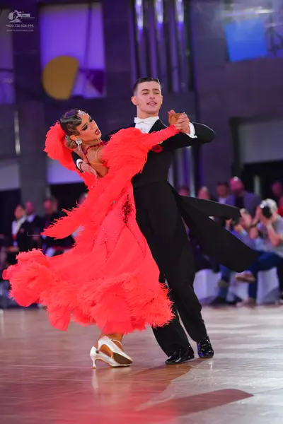 Dancesport competitor: Female dancer: bright red Latin dance dress with voluminous feathered or fringed
