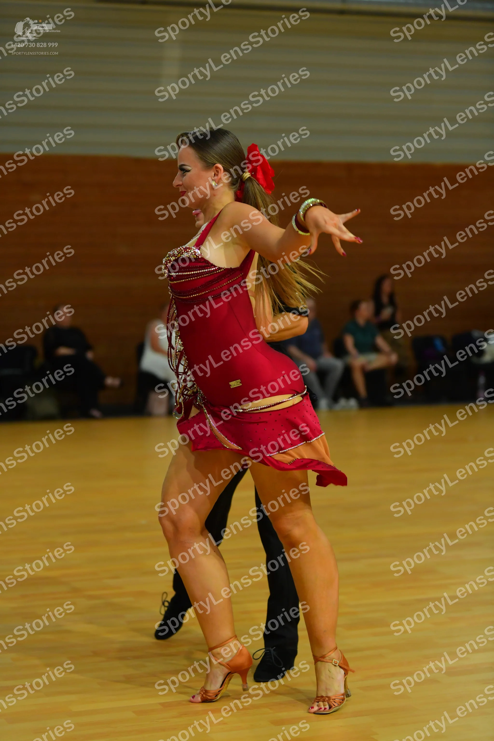 Dancesport competitor: Female dancer: red Latin dress with gold sequin trim on the straps and neckline,
