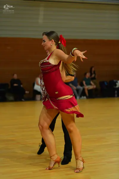 Dancesport competitor: Female dancer: red Latin dress with gold sequin trim on the straps and neckline,